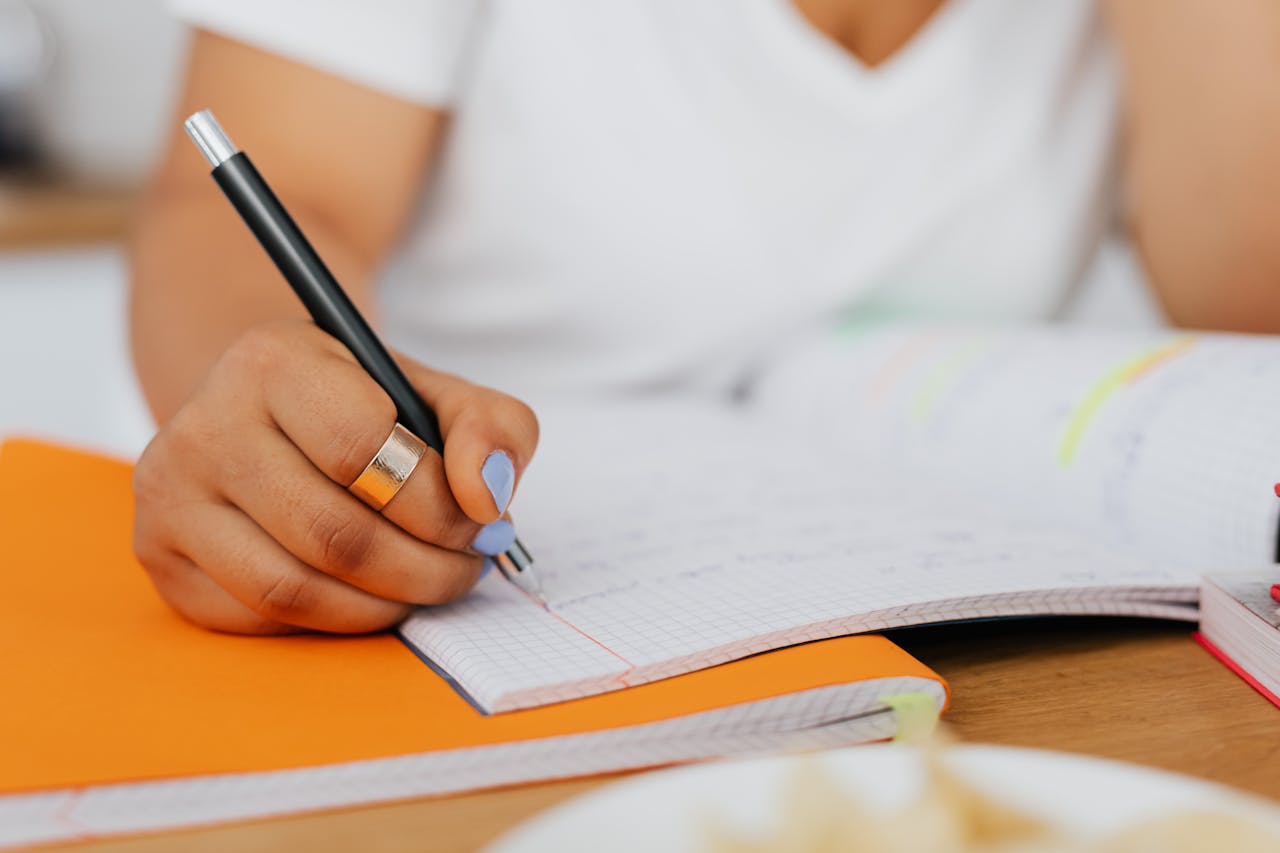 Mulher escrevendo em um caderno, representando as técnicas de estudos que serão tratadas na seção